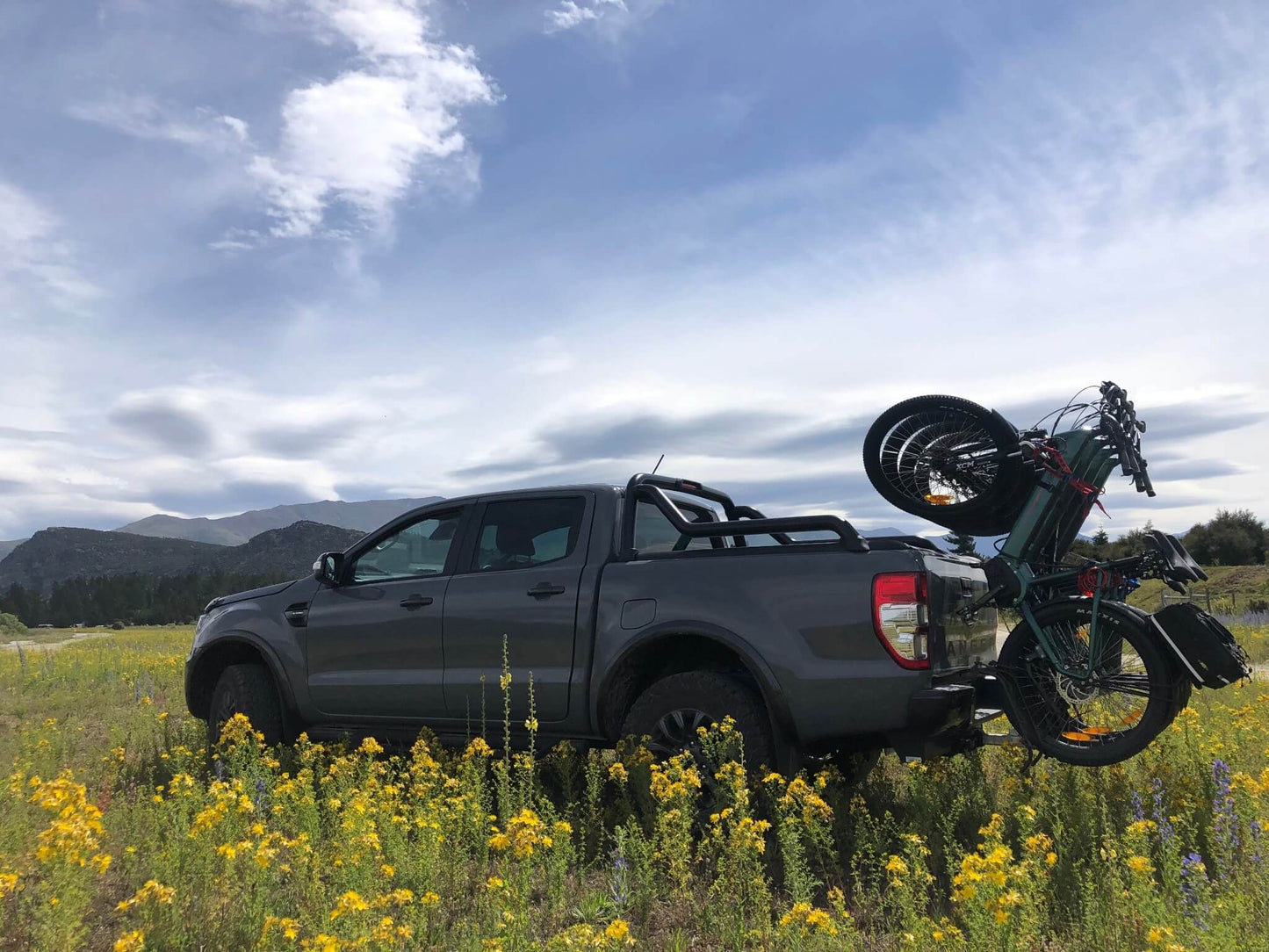 Truck with e-bikes parked in wildflower field