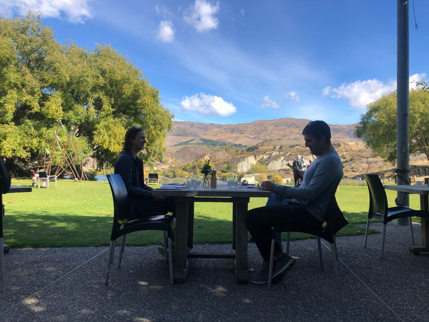 Couple enjoying outdoor dining with scenic views of Bannockburn hills