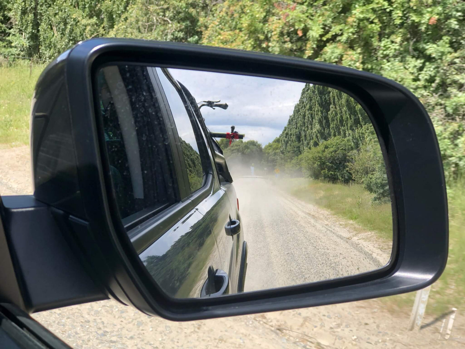 Bike on car reflected in mirror on Hawea River eBike adventure