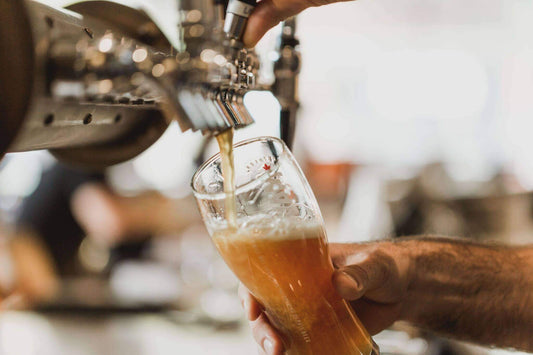 Fresh craft beer being poured from a tap into a tilted glass